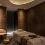 Phòng trị liệu spa với ánh sáng ấm gián tiếp và vật liệu gỗ tự nhiên