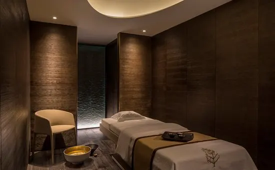 Phòng trị liệu spa với ánh sáng ấm gián tiếp và vật liệu gỗ tự nhiên